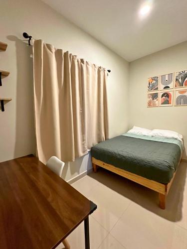 马萨特兰Condominio en Lomas de Mazatlán的一间小卧室,配有一张床和一张桌子