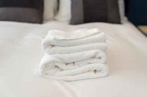 曼彻斯特Modern 4-Bed Retreat with Garden的床上的白色毛巾堆
