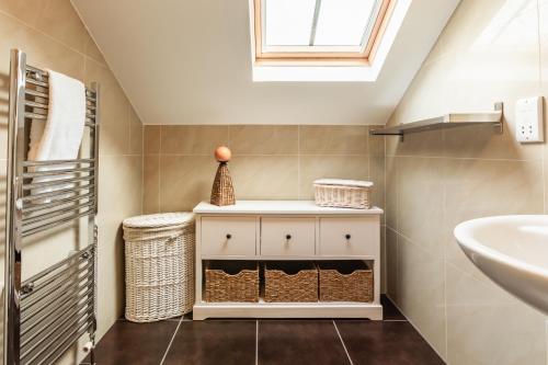 克雷尔Garden Cottage, Crail的一间带水槽和白色橱柜的浴室