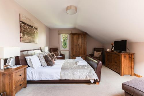 克雷尔Garden Cottage, Crail的一间卧室配有一张床、一张沙发和一台电视