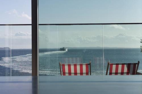 奥胡斯AArhus 115的两把椅子坐在窗户前,眺望着大海