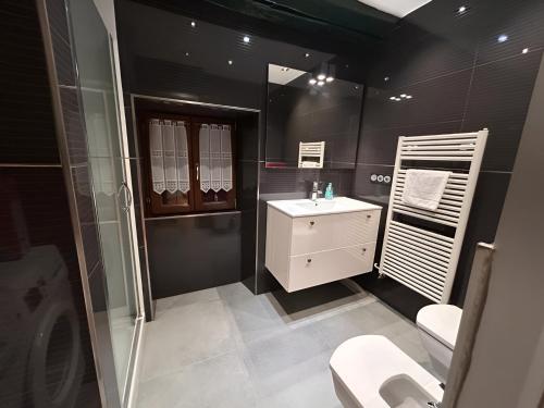 莱萨卡Apto ElizaG-1的黑色浴室设有水槽和卫生间