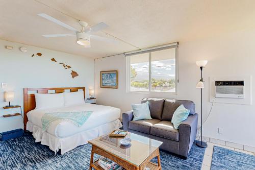 维雷亚Hale Li'ili'i at Keawakapu #201的一间卧室配有一张床、一张沙发和一把椅子