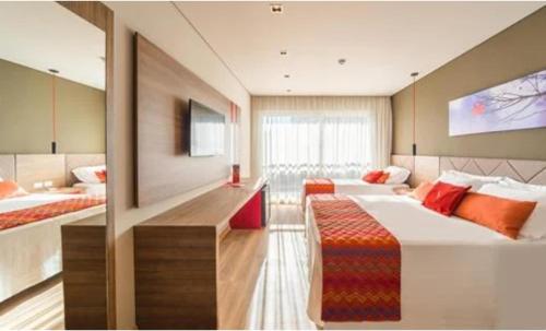 格拉玛多Hotel Laghetto Stilo Borges的一间大卧室,配有两张床和电视