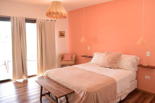 卢汉德库约Villa Mendotza的一间卧室配有一张大床和一把椅子