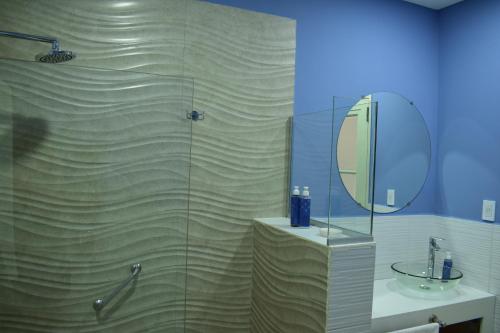 卢汉德库约Villa Mendotza的带淋浴、水槽和镜子的浴室
