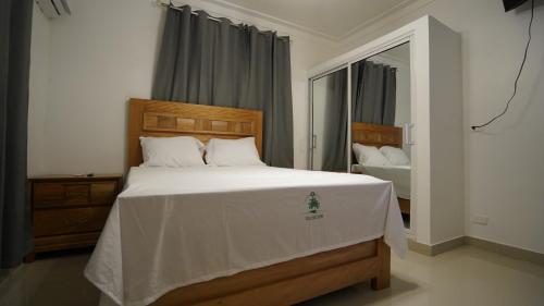 La GolondrinaVilla Sol Taino, Hotel en Boca chica, 5 minutos del Aeropuerto Internacional las Américas的卧室配有一张带镜子的白色大床