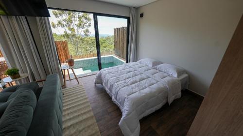 圣若热岛Vila Natur的一间卧室配有一张床,享有游泳池的景色