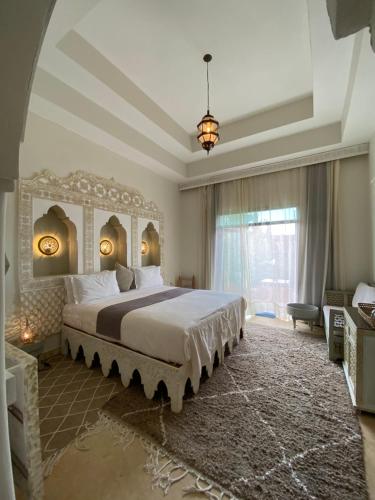 马拉喀什La Villa Des Golfs & PinkCactus的一间卧室设有一张大床和一个大窗户