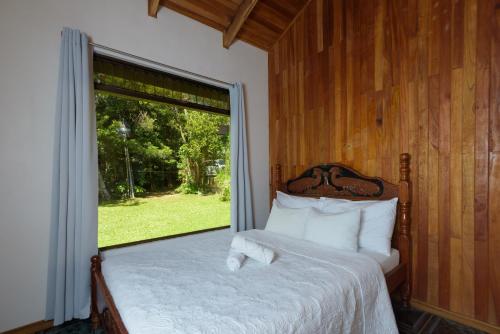 蒙泰韦尔德哥斯达黎加HeCo House的一间卧室设有一张大床和大窗户