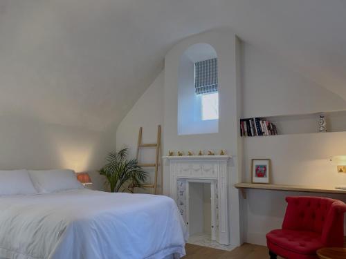 萨德伯里Forge Cottage Suffolk的一间卧室配有一张床和一张红色椅子