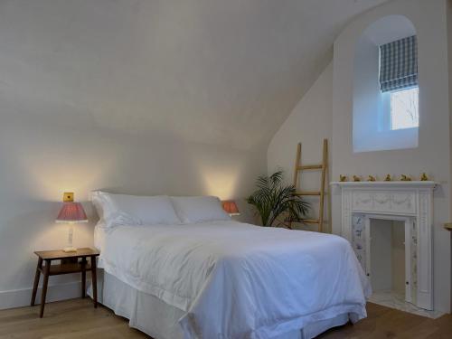 萨德伯里Forge Cottage Suffolk的卧室配有白色的床和壁炉