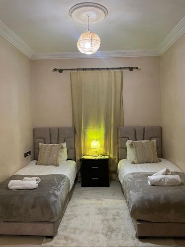 马拉喀什Kech Days appartement près de l'aéroport的一间卧室设有两张床和一扇光线充足的窗户。