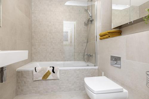 南布温Beach Front Getaway - Luxury Apt with Large Garden的带浴缸、卫生间和盥洗盆的浴室