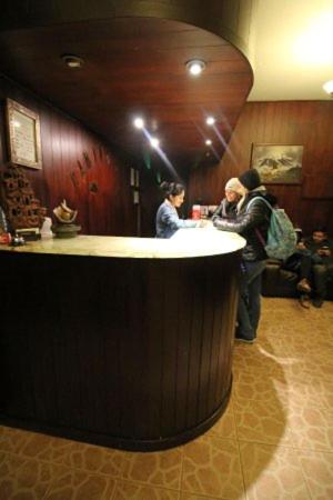 普诺Camino Real Puno的两名妇女站在餐厅酒吧