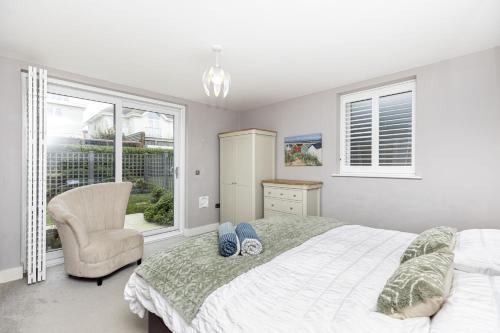 南布温Beach Front Getaway - Luxury Apt with Large Garden的卧室配有床、椅子和窗户。