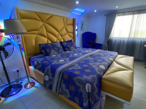 拉各斯The Residence Golden Tulip 2 Bedroom Apartment, Amuwo Lagos, Nigeria的一间卧室配有一张特大号床和蓝色被子
