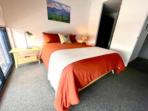 黄金海岸Ollies Place的一间卧室配有一张带橙色和白色毯子的床