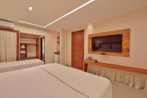 雅帕拉廷加胡玛提塔旅馆的一间卧室配有两张床和一台平面电视