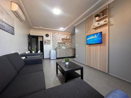 胡塞马Hotel Cataleya Al-Hoceima的客厅配有沙发和墙上的电视