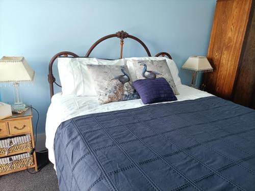 AwhituConnemara Country Lodge的蓝色卧室,配有一张床铺,上面有两只鸟