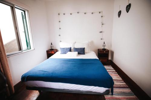圣维森特Casa da Avo Rosa的一间卧室配有一张带蓝色毯子的床