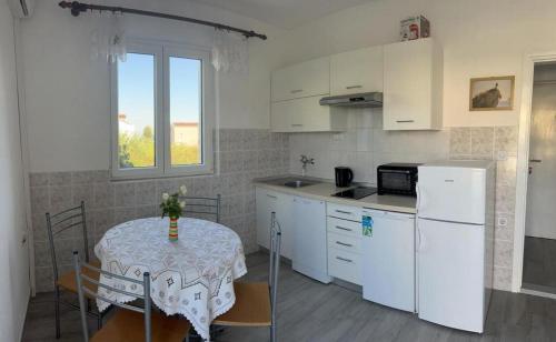 维拉斯奇Apartments with a parking space Vlasici, Pag - 4139的厨房配有桌子和白色冰箱。
