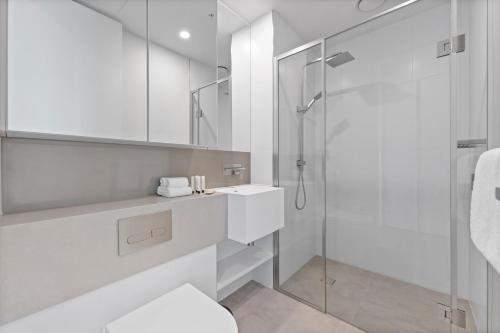 墨尔本Aspire Melbourne的带淋浴和盥洗盆的白色浴室