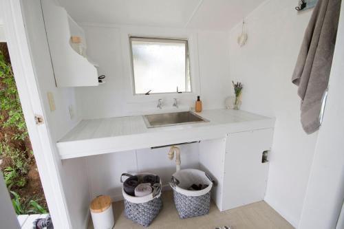 怀蒂昂格The Cowshed的白色的厨房,配有水槽和2个垃圾桶