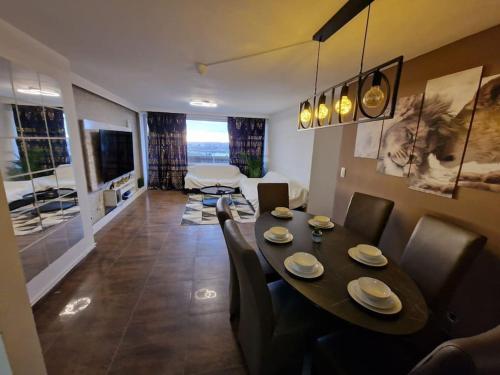 布鲁塞尔Appart meublé 92m2 + 2 terrasses的用餐室以及带桌椅的起居室。