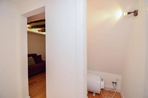 里斯本Oleiro 7的一间设有白色墙壁的房间和一间带床的房间
