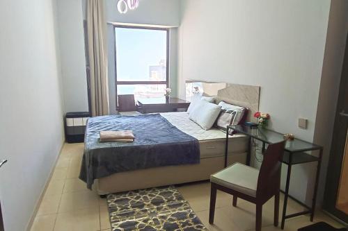 迪拜ocean view Dubai Marina JBR walk comfort room的卧室配有床、椅子和窗户。