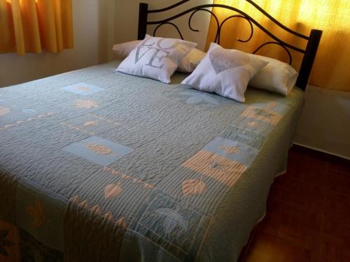 埃斯克尔Vicos的一张带两个枕头的床和蓝色毯子