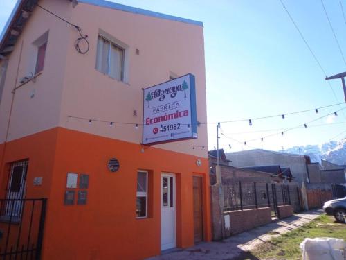 埃斯克尔Vicos的一座橙色和白色的建筑,上面有标志