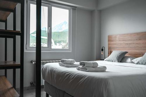 乌斯怀亚Las Cumbres Ushuaia的一间卧室配有一张大床和毛巾