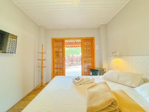 塞拉内格拉Pousada Ar da Montanha的卧室配有白色床和毛巾