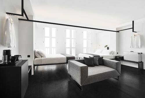 新加坡Hotel Mono的客厅配有沙发、一张床和椅子