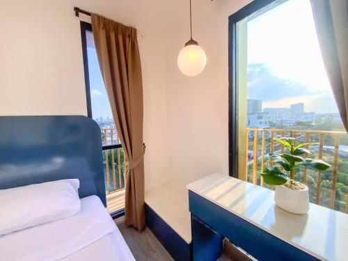 曼谷Goldsmith Bangkok Residence的一间卧室配有一张床和一个植物窗户