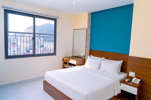 头顿Hai Duong Vung Tau Hotel - Khách sạn Hải Dương Vũng Tàu的一间卧室设有一张床和一个大窗户