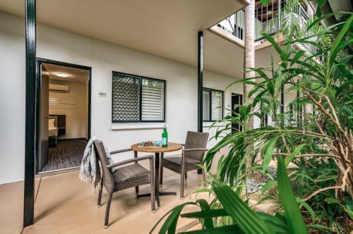 达尔文棕榈城度假酒店的庭院配有桌椅和植物
