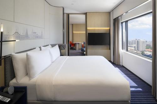 曼谷Crowne Plaza Bangkok Lumpini Park, an IHG Hotel的卧室设有一张白色大床和大窗户