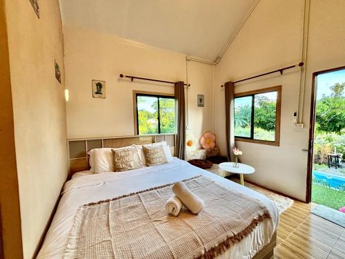 清刊บ้านสวนโอเชี่ยน Ocean Garden Home的一间带一张大床的卧室,位于带窗户的房间内