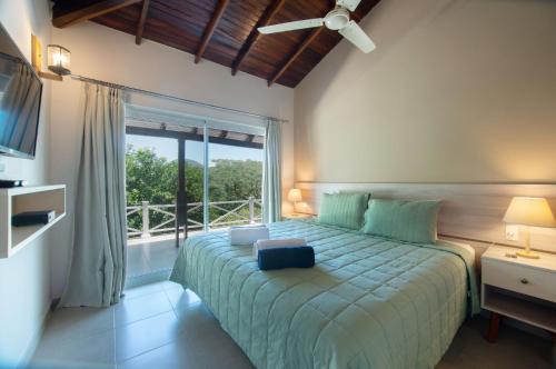 IndependenciaVista Alegre Natural Resort - Villas & Cabañas的一间卧室设有一张大床和大窗户