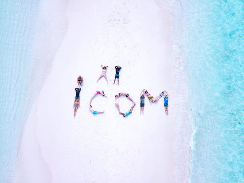 马富施iCom Marina Sea View的一群站在海滩上的人,形成了爱这个词
