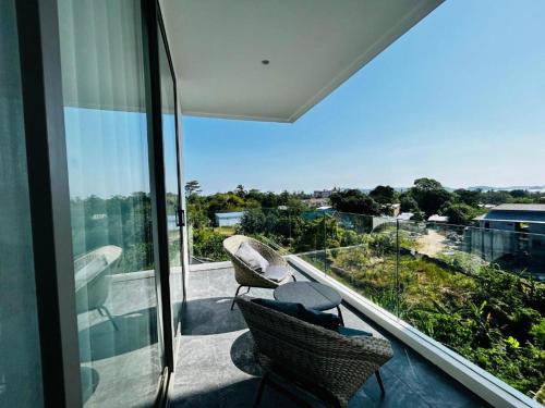 拉威海滩Luxury Resort Rawai的阳台配有两把椅子,享有建筑的景致。