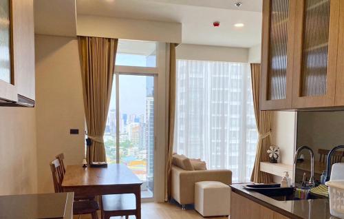 曼谷2 Bedroom Luxury Apartment 3 min walk from BTS Ekkamai的厨房和带大窗户的客厅