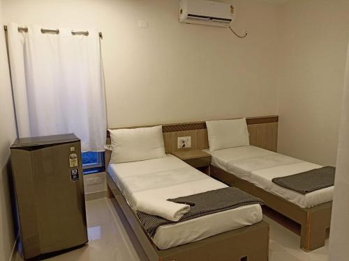 菩提伽耶Hotel Jataka Inn , Bodh Gaya的小房间设有两张床和暖气
