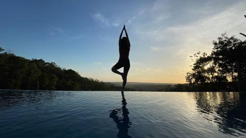 班图尔拉贾克拉纳度假酒店和Spa中心的做瑜伽的女人在水中摆姿势
