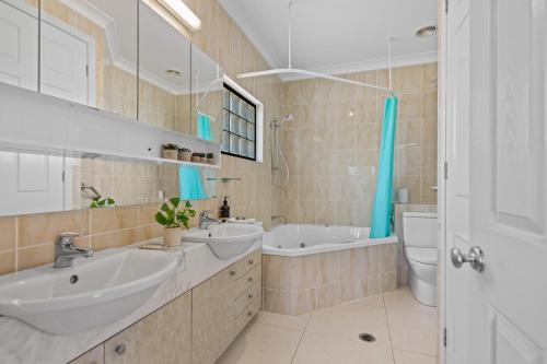 布里斯班Luxury 2-Bed Penthouse with Rooftop and Parking的一间带两个盥洗盆、浴缸和卫生间的浴室