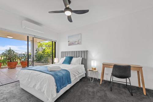 布里斯班Luxury 2-Bed Penthouse with Rooftop and Parking的一间卧室配有一张床、一张书桌和一个窗户。